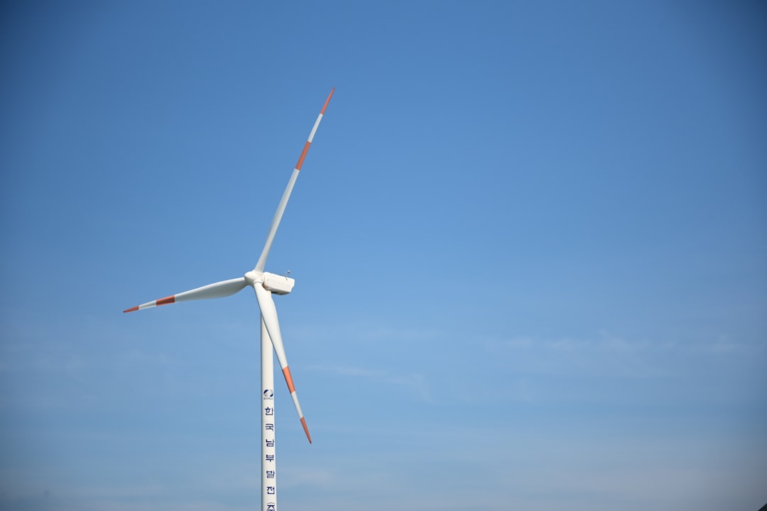 a-white-wind-turbine-against-a-clear-blue-sky-ozr8-aqbjp8